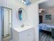 Bright bathroom has a sleek vanity, mirror, and access to an adjacent bedroom and closet at 2606 Oak Cir, Tarpon Springs, FL 34689