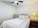 Bright bedroom features a full size bed, ceiling fan, and a dresser with plenty of natural light at 2606 Oak Cir, Tarpon Springs, FL 34689