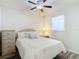 This bedroom has a comfortable bed, a ceiling fan, and a window for natural light, with a storage dresser at 2606 Oak Cir, Tarpon Springs, FL 34689