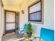Inviting front porch with seating area and charming decor, bathed in soft sunlight, creating a welcoming entrance at 2606 Oak Cir, Tarpon Springs, FL 34689