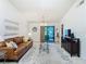 The living room boasts a comfortable leather sofa, glass tables, and sliding doors to a private outdoor patio at 2606 Oak Cir, Tarpon Springs, FL 34689