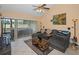 The cozy living room features tile floors, a vaulted ceiling with a fan, a TV, and natural light from sliding glass doors at 3118 Eagles Landing W Cir, Clearwater, FL 33761