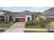 Beautiful aerial view of a single-story home with a brick driveway, well-kept landscaping, and a sleek roof at 31675 Cannon Rush Dr, San Antonio, FL 33576