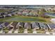 Aerial view of single-Gathering homes in a planned community with lush landscaping and a serene pond, showcasing the neighborhood at 31675 Cannon Rush Dr, San Antonio, FL 33576