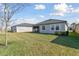 Backyard with a lush lawn, screened-in patio, and views of the surrounding homes, perfect for outdoor enjoyment at 31675 Cannon Rush Dr, San Antonio, FL 33576