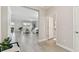 Hallway leading to a bright living room, featuring tiled flooring and access to a half bathroom at 31675 Cannon Rush Dr, San Antonio, FL 33576