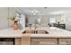 Bright kitchen island with a stainless steel sink and a view of dining and living area at 31675 Cannon Rush Dr, San Antonio, FL 33576