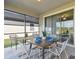 Enclosed patio with dining table and view of the backyard, providing a relaxing outdoor dining space at 31675 Cannon Rush Dr, San Antonio, FL 33576