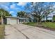 Charming home featuring a lush lawn, a large tree, and a concrete driveway at 3933 60Th N St, St Petersburg, FL 33709