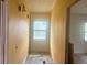 Narrow hallway with yellow walls, window, and unfinished flooring, ready for renovation at 4004 27Th Se St, Ruskin, FL 33570