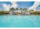 Community pool featuring palm trees, lounge chairs, a pergola, and a clear blue swimming area at 4006 Northern Key Dr, Plant City, FL 33563