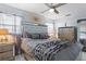 This main bedroom features gray bedding, a ceiling fan, and mirror-trimmed furniture at 4106 W Bay View Ave, Tampa, FL 33611