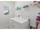 Functional laundry room featuring a window, washer, dryer, and shelving at 5914 Hidden Branch Dr, Apollo Beach, FL 33572