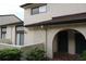 Exterior elevation featuring an arched entry, textured siding, and a brown roof at 6262 142Nd Ave # 506, Clearwater, FL 33760