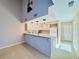 Open kitchen with white cabinets, granite countertops, and a bar overlooking the living area at 6262 142Nd Ave # 506, Clearwater, FL 33760