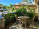 Cozy outdoor patio space with dining set, shade umbrella, and manicured landscaping at 6262 142Nd Ave # 506, Clearwater, FL 33760