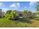 The backyard features lush green grass and tropical plants at 7634 Nottinghill Sky Dr, Apollo Beach, FL 33572