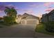 Charming home featuring a three-car garage and mature landscaping at 7634 Nottinghill Sky Dr, Apollo Beach, FL 33572