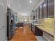 Open kitchen layout with dark cabinetry, stainless steel appliances, and access to the dining area at 7634 Nottinghill Sky Dr, Apollo Beach, FL 33572