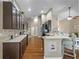 Spacious kitchen featuring dark cabinets, stainless steel appliances, and a breakfast bar with seating at 7634 Nottinghill Sky Dr, Apollo Beach, FL 33572