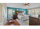 Inviting main bedroom featuring a calming blue accent wall, ceiling fan, and window seat at 7634 Nottinghill Sky Dr, Apollo Beach, FL 33572