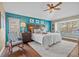 Stylish main bedroom with a vibrant blue wall, ceiling fan, and inviting decor at 7634 Nottinghill Sky Dr, Apollo Beach, FL 33572