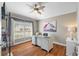 Well-lit office space with wood floors, a decorative ceiling fan, and a modern white work desk at 7634 Nottinghill Sky Dr, Apollo Beach, FL 33572