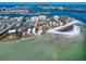Stunning aerial view of waterfront condo complex with beach access and city skyline in the distance at 825 S Gulfview Blvd # 208, Clearwater Beach, FL 33767