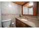 Bathroom features a light-tiled wall with wood cabinets and a large framed mirror at 825 S Gulfview Blvd # 208, Clearwater Beach, FL 33767