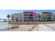 Waterfront condo building with balconies overlooking sandy beach with outdoor seating and waterfront views at 825 S Gulfview Blvd # 208, Clearwater Beach, FL 33767