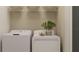 Functional laundry room with modern washer and dryer, shelving, and neutral decor at 9304 Bonita Mar Dr, Parrish, FL 34219