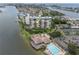 Stunning aerial view of waterfront condo showcasing building amenities: pool, dock, and tennis courts at 9425 Blind Pass Rd # 507, St Pete Beach, FL 33706