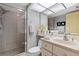 Bright bathroom featuring a glass shower, single sink vanity, and mirrored medicine cabinet at 9425 Blind Pass Rd # 507, St Pete Beach, FL 33706