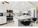 Updated white kitchen features stainless appliances and a breakfast bar with stylish black stools at 9425 Blind Pass Rd # 507, St Pete Beach, FL 33706