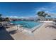 Large community pool overlooks calm waters, with surrounding lounge chairs and palm trees at 9425 Blind Pass Rd # 507, St Pete Beach, FL 33706