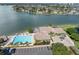 Aerial view of luxurious community pool surrounded by lounge chairs and manicured landscaping overlooking water at 9425 Blind Pass Rd # 507, St Pete Beach, FL 33706