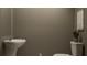 This bathroom features a modern toilet, unique sink, and neutral colors at 9452 Runaway Breeze Dr, Land O Lakes, FL 34637