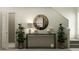 Inviting entryway featuring a round mirror, console table, and decorative plants at 9452 Runaway Breeze Dr, Land O Lakes, FL 34637