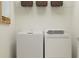 Functional laundry room with a washing machine, dryer, and wire shelving at 9452 Runaway Breeze Dr, Land O Lakes, FL 34637