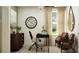 Bright office with a dark desk, two chairs, decorations, and natural light from the window at 9452 Runaway Breeze Dr, Land O Lakes, FL 34637