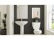 Stylish half bath features pedestal sink, modern fixtures, and elegant accents in neutral tones at 9455 Runaway Breeze Dr, Land O Lakes, FL 34637