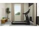 Home gym featuring a black treadmill in front of a window with natural light at 9455 Runaway Breeze Dr, Land O Lakes, FL 34637