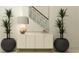 Hallway featuring a decorative buffet, lamp, plants, and a view of the staircase at 9455 Runaway Breeze Dr, Land O Lakes, FL 34637