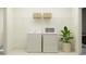 Functional laundry room with modern washer, dryer, and overhead storage at 9455 Runaway Breeze Dr, Land O Lakes, FL 34637