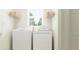 Well-lit laundry room featuring a washer, dryer, shelves, and a window at 9468 Runaway Breeze Dr, Land O Lakes, FL 34637