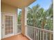A cozy balcony featuring a small door, white railings, and views of the flourishing surrounding palm trees at 1216 S Missouri Ave # 224, Clearwater, FL 33756