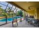Covered lanai with outdoor seating overlooking the screened in pool and fenced in backyard at 10534 Bermuda Isle Dr, Tampa, FL 33647