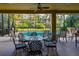 Covered patio with a ceiling fan, outdoor dining furniture, and a view of the sparkling pool and lush landscaping at 10534 Bermuda Isle Dr, Tampa, FL 33647