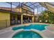 Home features a screened in pool with spa, overlooking a backyard with tropical landscape at 10534 Bermuda Isle Dr, Tampa, FL 33647