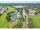 Aerial view of the property featuring tennis and shuffleboard courts, a community center, and green spaces at 11138 Brooklawn Dr, Hudson, FL 34667
